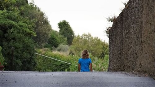 Rear view of a girl overlooking trees