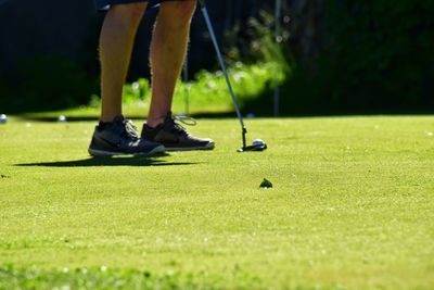 Low section of man standing on golf course