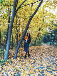 Full length of woman standing in forest