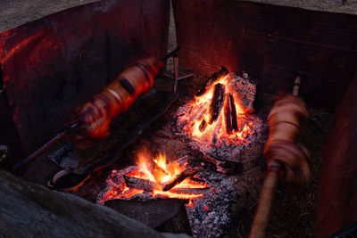 Two whole pig roasting on spit