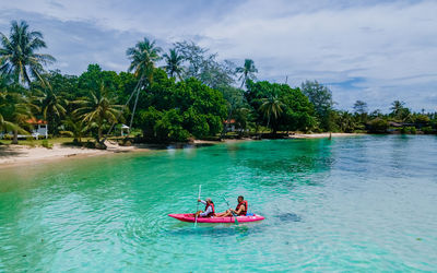 People in boat in sea against sky