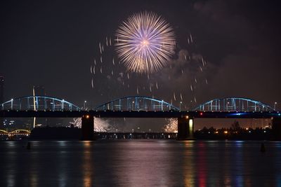 Firework display over river at night