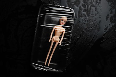 Directly above shot of doll wrapped in container on table