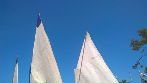 Low angle view of flag against clear blue sky