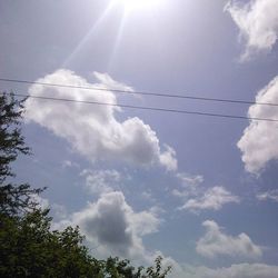 Low angle view of power lines against cloudy sky