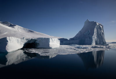 Massive iceberg at coastlien of greenland at sunny day with dark blue sky