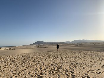 Full length of woman on desert against clear sky