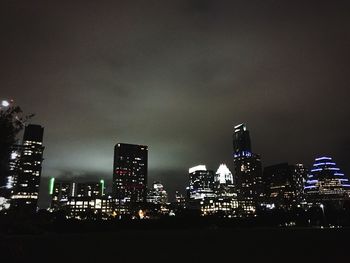 Low angle view of illuminated cityscape against sky at night