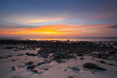 Scenic view of beach against sky during sunset