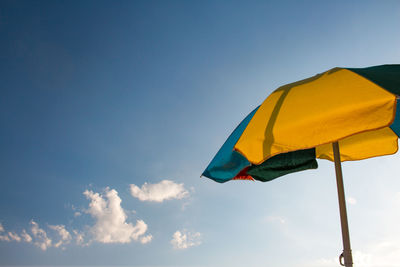 Low angle view of flag against blue sky