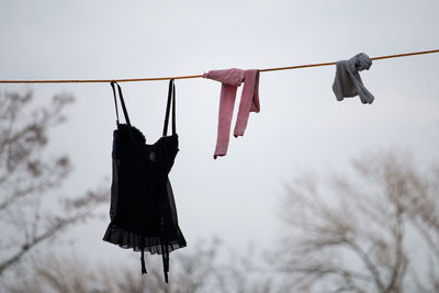 Low angle view of clothes hanging on clothesline against sky