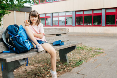 Young woman sitting on bench in park