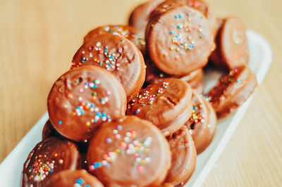 Gourmet chocolate covered oreos with colorful sprinkles on top.