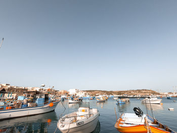 Sailboats moored in harbor