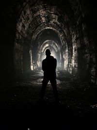 Rear view of silhouette man standing in abandoned building