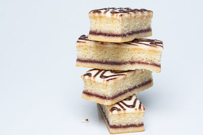 Close-up of cake on stack against white background