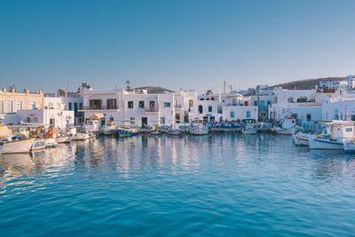 Boat moored on sea against buildings