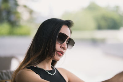 Close-up portrait of young woman wearing sunglasses