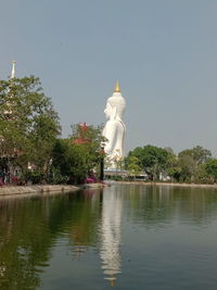 View of building by lake against sky