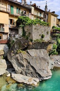 Rocks by river against buildings