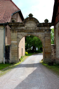 Footpath amidst buildings against sky