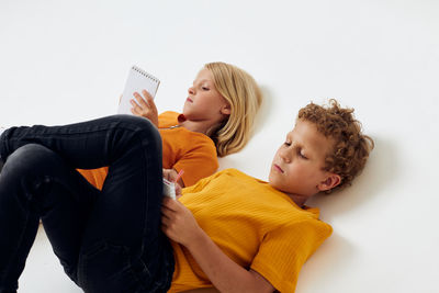 Side view of woman using mobile phone against white background