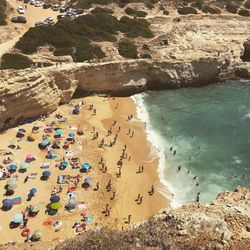 High angle view of people on beach by rock formations