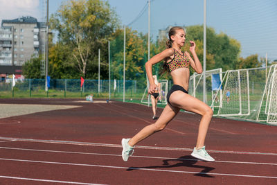 Full length of woman exercising on road