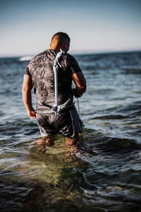 Man in sea against sky