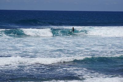 Man surfing in sea against clear sky