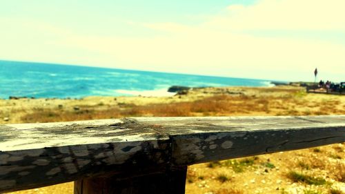 Close-up of wood by sea against sky