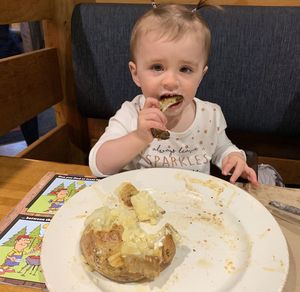 Portrait of cute girl eating food at home