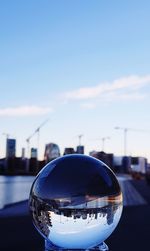 Close-up of crystal ball against blue sky