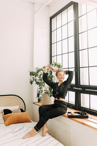 Woman sitting on table by window