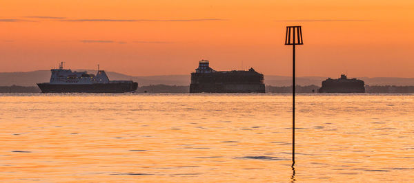 Scenic view of sea against orange sky