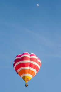 Low angle view of hot air balloon flying in blue sky