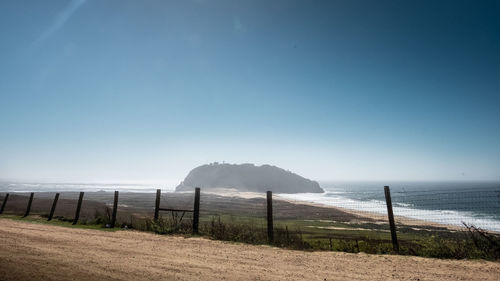 Scenic view of beach against clear blue sky