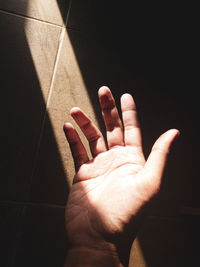 Close-up of hand on tiled floor