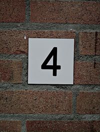 Close-up of sign on brick wall