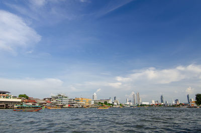 Sea by buildings against sky