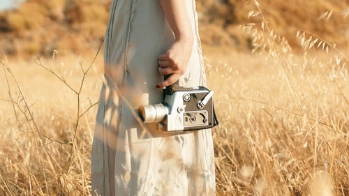 Beautiful girl in the countryside in summer with vintage 8mm camera