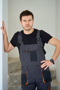 Portrait of boy standing against wall