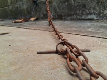 Close-up of rope tied to rusty metal chain