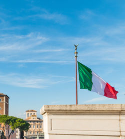 Low angle view of flag on building against sky