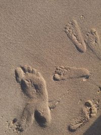 High angle view of footprints on sand at beach