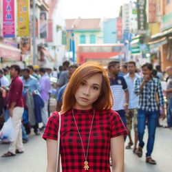 Portrait of beautiful young woman standing on street in city