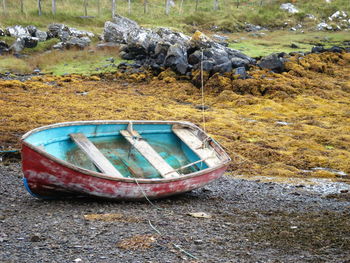 Abandoned boat moored on shore