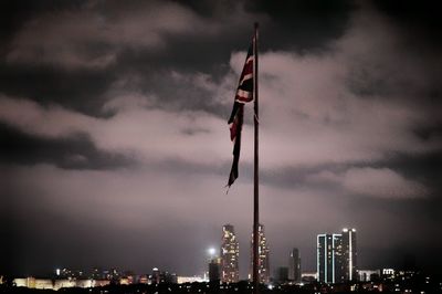 Skyscrapers in city against cloudy sky