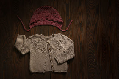 Children's wardrobe, knitted blouses and hats on a wooden background, the concept of autumn 