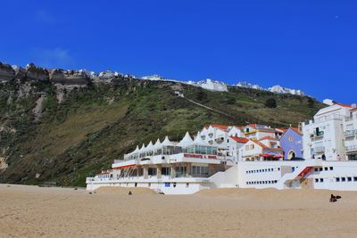 Buildings at beach against blue sky